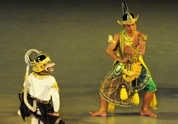 alt="Javaanse dansers tijdens het Ramayana Ballet met de verlichte Prambanan Tempel op de achtergrond"