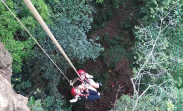 Avontuurlijke toerist daalt af in de Jomblang Grot met een professioneel touwsysteem.