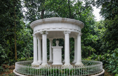 Monument Lady Raffles, een witte ronde rotunda met zuilen in een groen park omringd door bomen.